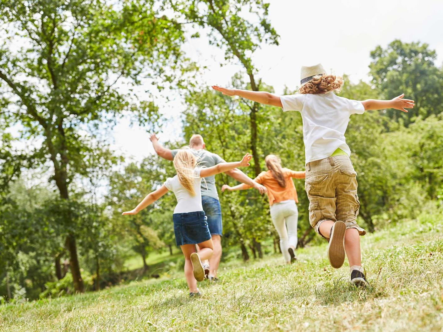Familie spielt draußen auf einer Wiese