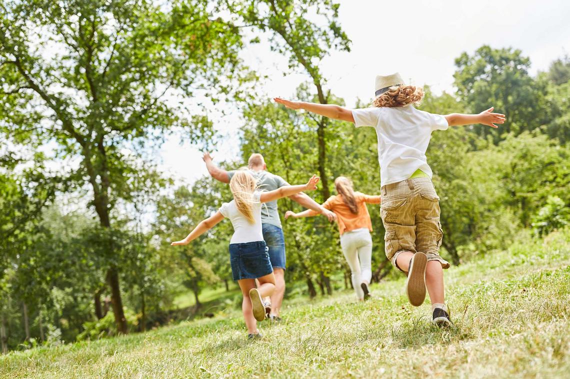 Familie spielt draußen auf einer Wiese